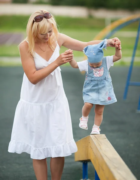 Moeder met dochter op horizontale balk evenwicht — Stockfoto