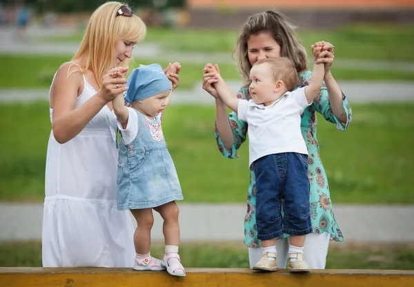 Матери со своими детьми на детской площадке — стоковое фото