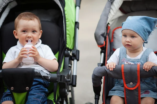 Niedliche Babygetränke Saft im Kinderwagen sitzen — Stockfoto