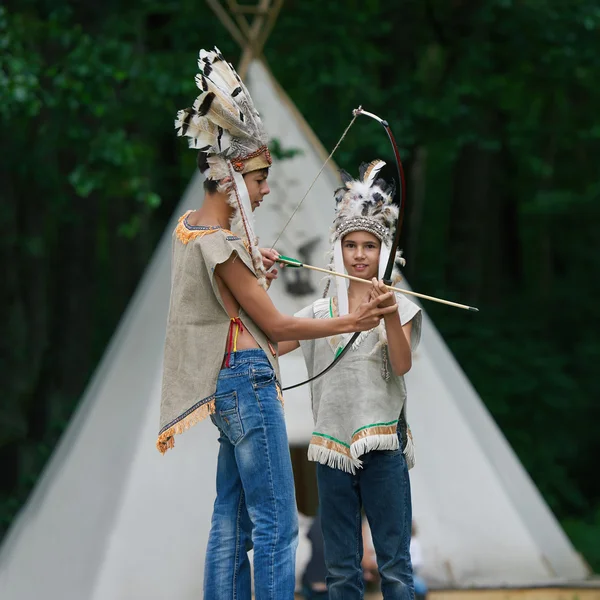 Glada barn som leker indianer — Stockfoto