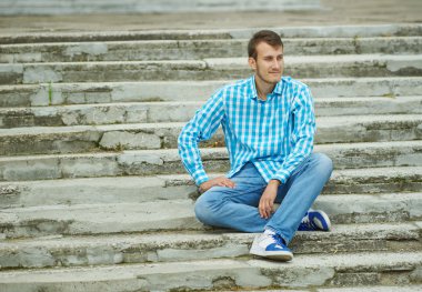 merdivenlerde oturan genç hippi çocuk