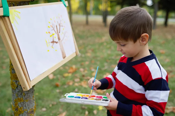 Little happy boy drawing in park — Stock Photo, Image