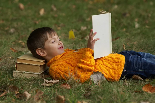 Kleine jongen sying op stapel boeken — Stockfoto