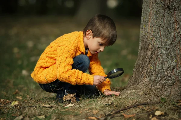 Pequeno menino feliz com lupa — Fotografia de Stock