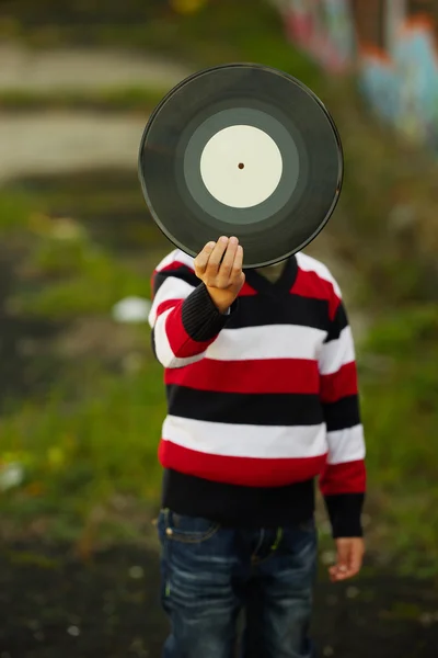 Liten pojke gömmer sig bakom vinyl plattan — Stockfoto