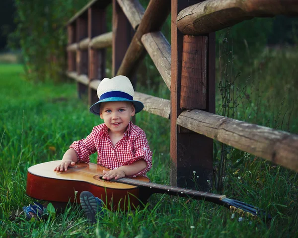 Roztomilý malý kovboj hrací kytara — Stock fotografie