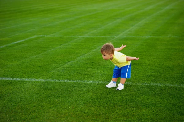 Little funny boy on football field — Stock Photo, Image