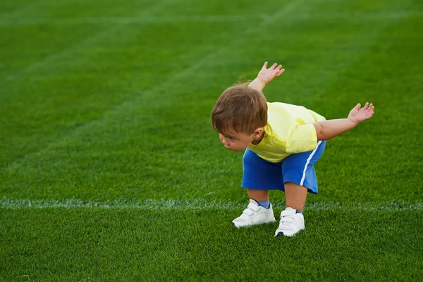 Little funny boy on football field — Stock Photo, Image