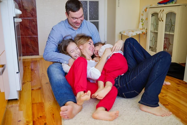 Familia feliz en casa en el suelo —  Fotos de Stock