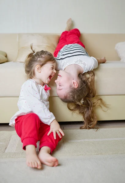 Cute girls on the couch upside down — Stock Photo, Image