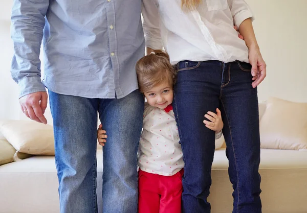 Girl hugging mom and dad for legs — Stock Photo, Image