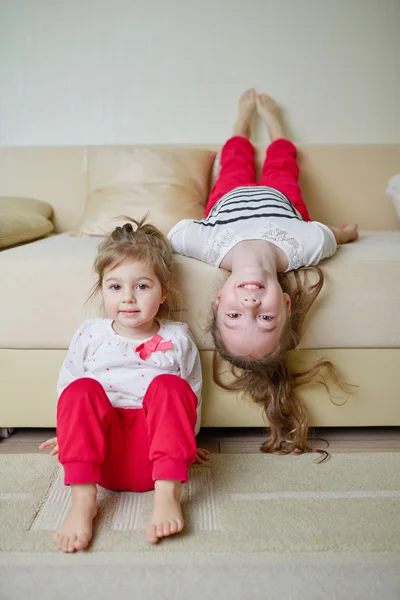 Cute girls on the couch upside down Royalty Free Stock Images