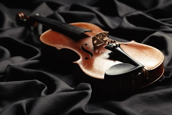 Aged violin on dark texture — Stock Photo, Image