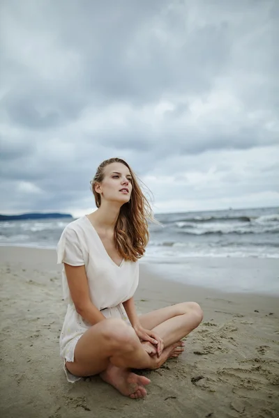 Giovane bella donna sulla spiaggia ventosa fredda — Foto Stock