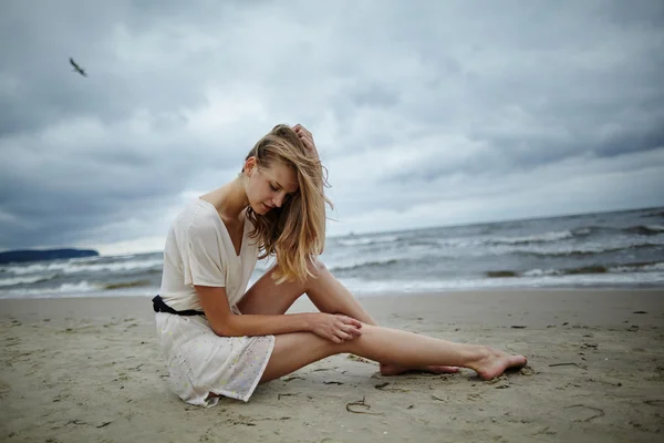 Mladá krásná žena na studené větrné pláži — Stock fotografie