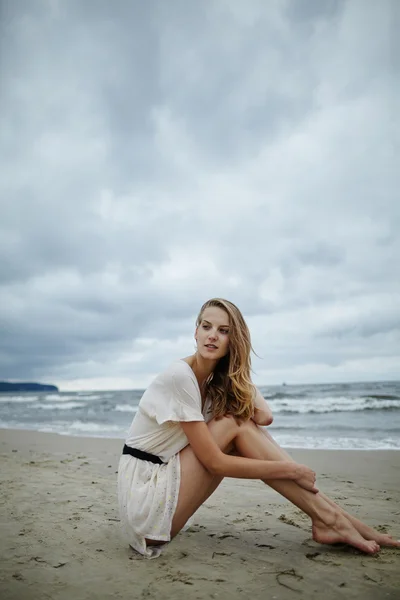 Joven hermosa mujer en frío ventoso playa — Foto de Stock