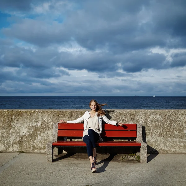 Bela mulher loira sentada no banco — Fotografia de Stock