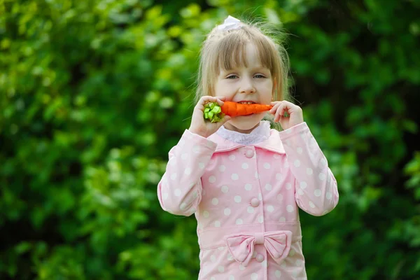 Маленькая девочка с морковкой — стоковое фото