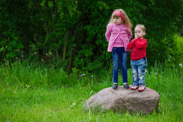 Little girls standing on big stone — Stock Photo, Image