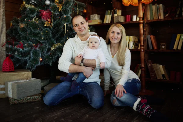 Glückliche Familie im weihnachtlich dekorierten Zimmer — Stockfoto