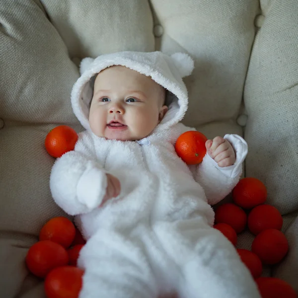 Roztomilé dítě s mnoha mandarinky — Stock fotografie
