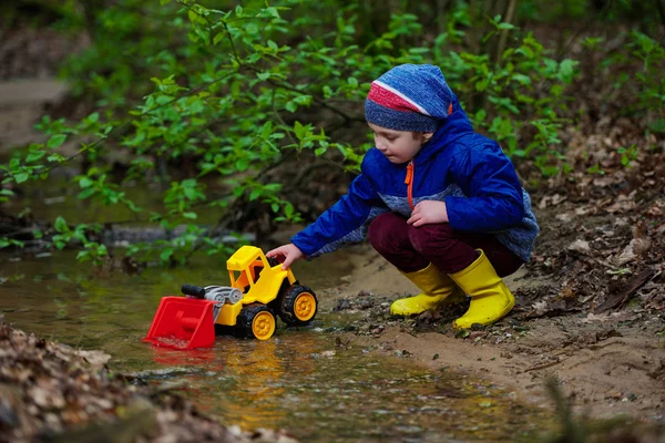 Funny boy playing with excavator — Stock Photo, Image