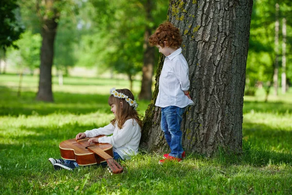 Niedliche Kinder spielen Gitarre — Stockfoto