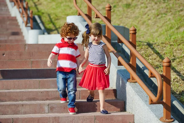 Boy and girl walking on stairway — Stock Photo, Image