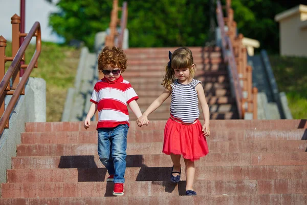 Boy and girl walking on stairway — Stock Photo, Image