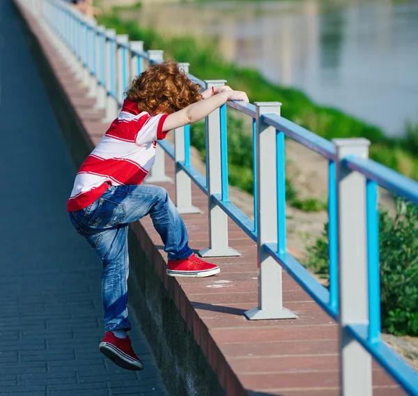 Ragazzo arrampicata oltre la recinzione — Foto Stock