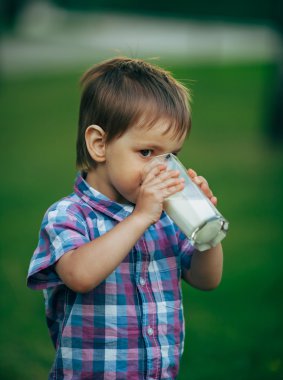 Bir bardak sütle küçük komik çocuk.