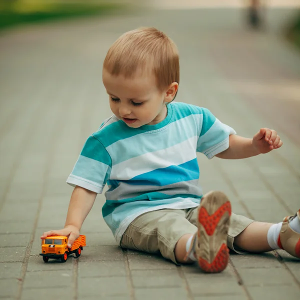 Маленький мальчик играет с игрушечной машиной — стоковое фото