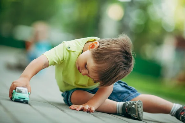 Küçük çocuk oyuncak arabayla oynuyor.