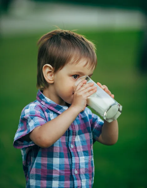 Pequeño niño divertido con vaso de leche — Foto de Stock