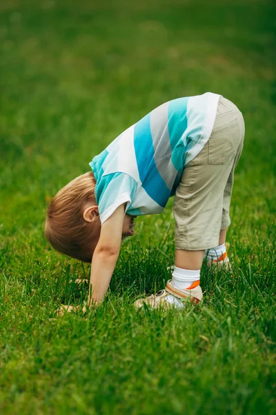 Little boy looks upside down — Stock Photo, Image