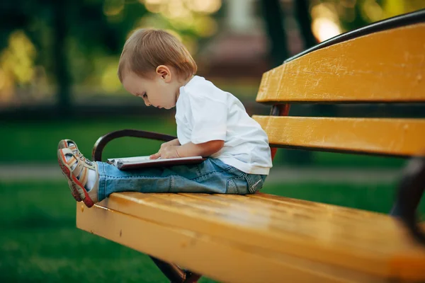 Piccolo ragazzo di lettura nel parco estivo — Foto Stock
