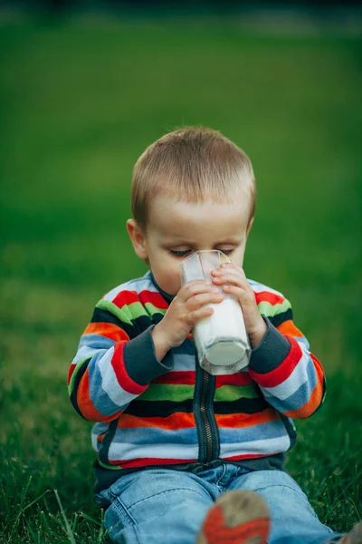 우유를 들고 있는 작고 재미있는 소년 — 스톡 사진