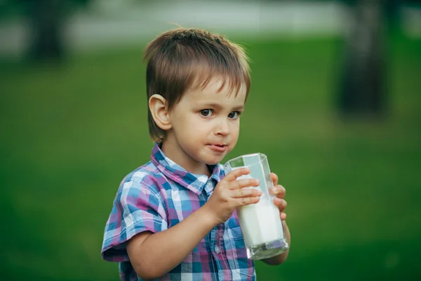 Menino engraçado com copo de leite — Fotografia de Stock