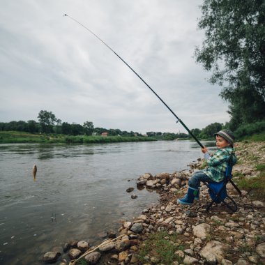 nehir kıyısında balık tutan çocuk