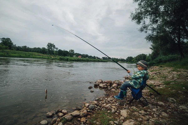 Jongen vissen aan de kust van rivier — Stockfoto