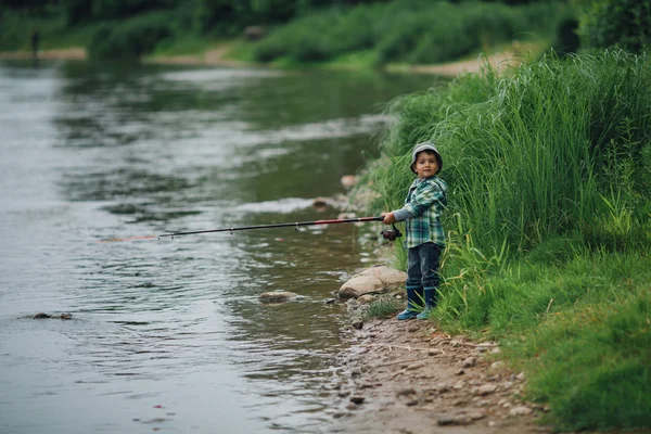 Jongen vissen aan de kust van rivier — Stockfoto