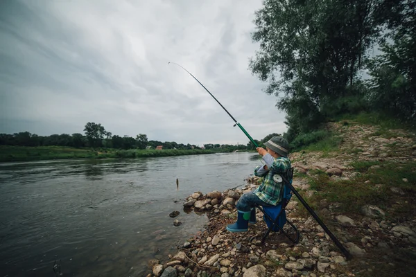 Jongen vissen aan de kust van rivier — Stockfoto