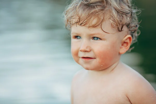 Menino engraçado brincando na água — Fotografia de Stock