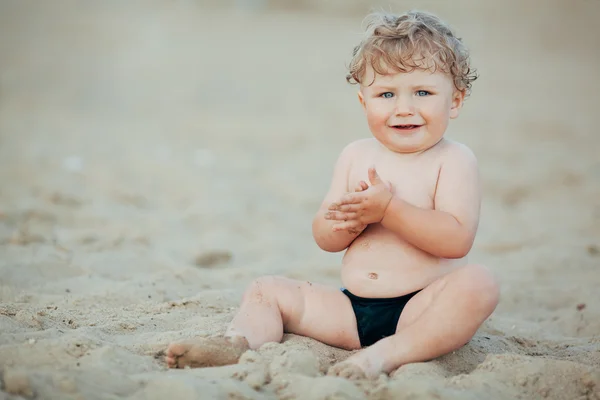 Little funny boy plays on beach — Stock Photo, Image