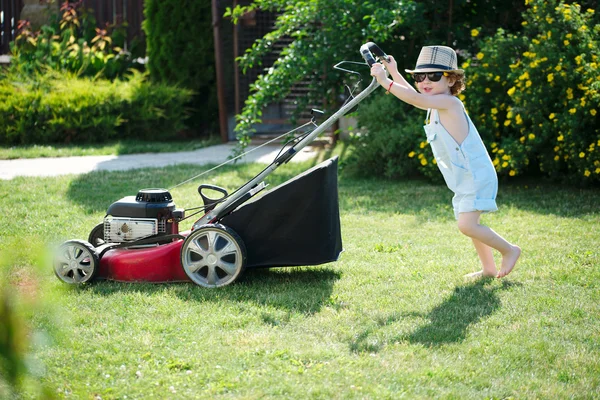 Little boy mows lawn with mower — Stock Photo, Image