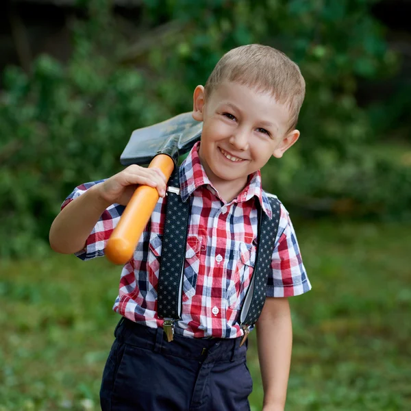 Grappige jongen met de schop in de tuin — Stockfoto