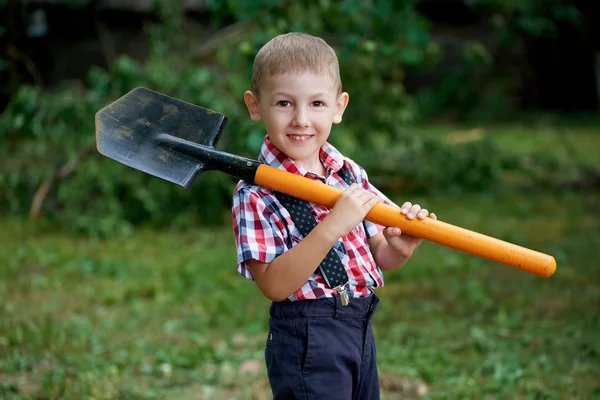 Funny boy med spade i trädgården — Stockfoto