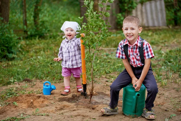 Смішний хлопчик з лопатою в саду — стокове фото