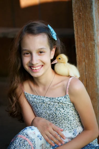 Girl with little yellow duckling in summer village — Stock Photo, Image