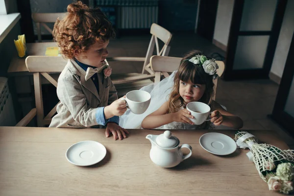 Chico y chica teniendo una fiesta de té en la cafetería — Foto de Stock